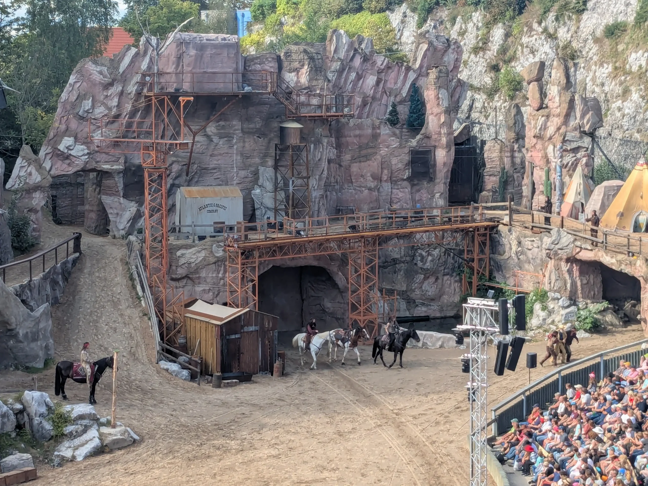 Westernshow-Arena mit Pferden, Darstellern und Felsenkulisse vor vollem Publikum