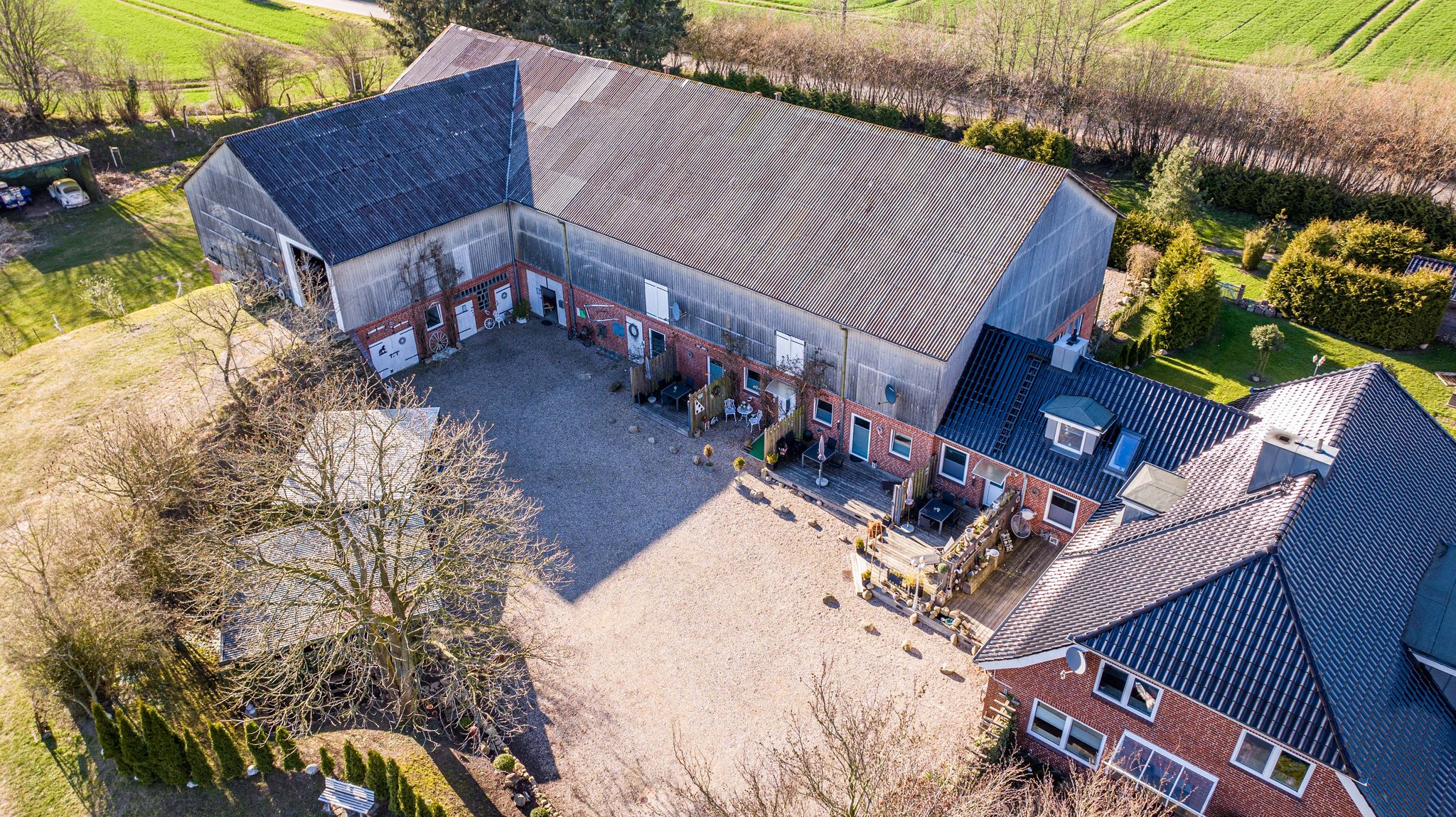Luftaufnahme von Hof Gayenberg: Scheune, Ferienwohnungen mit Terrassen und Wohnhaus im Innenhof