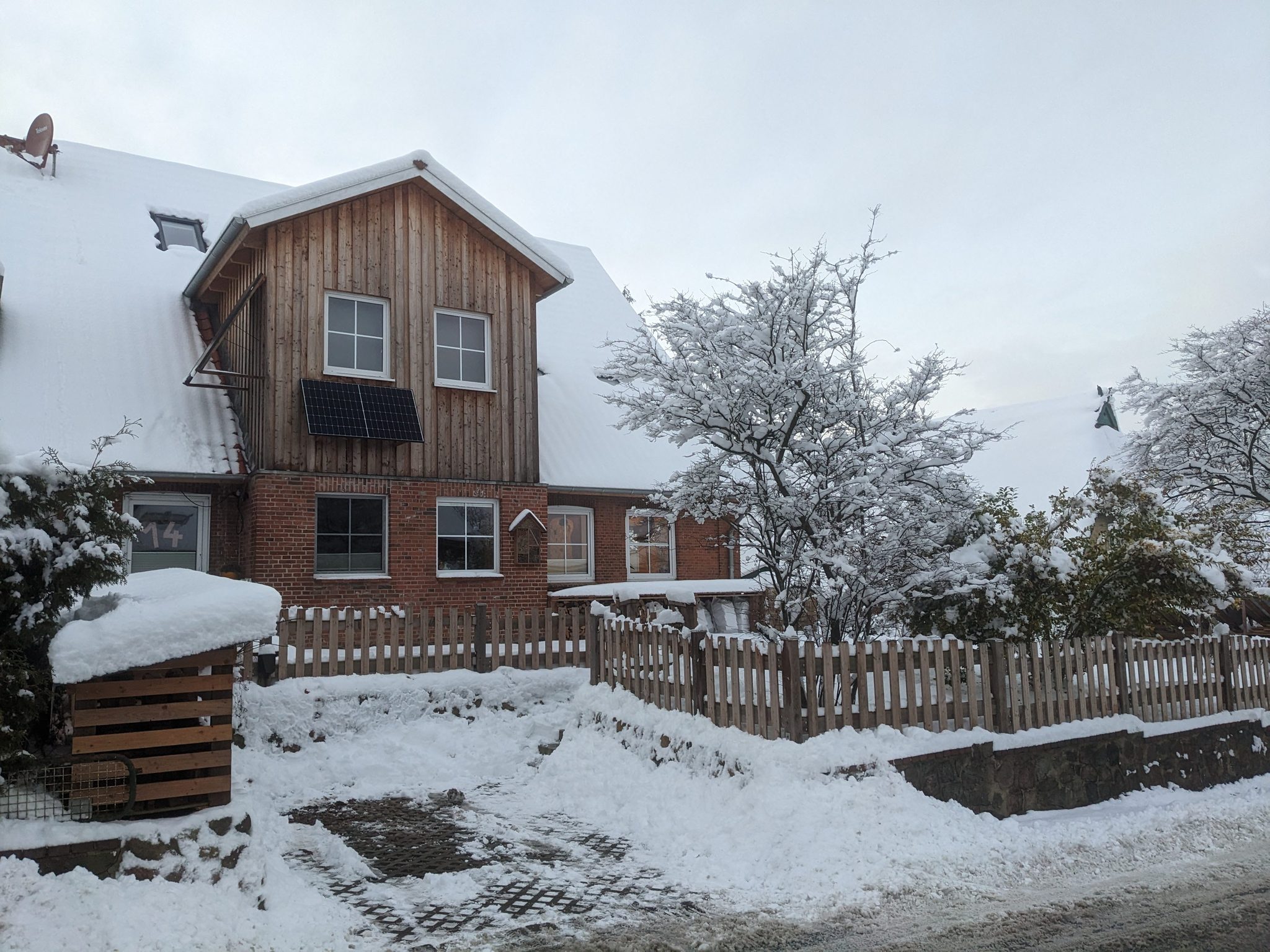 Hof Gayenberg im Winter: Fachwerkhaus mit Backsteinsockel, Holzzaun und verschneitem Garten